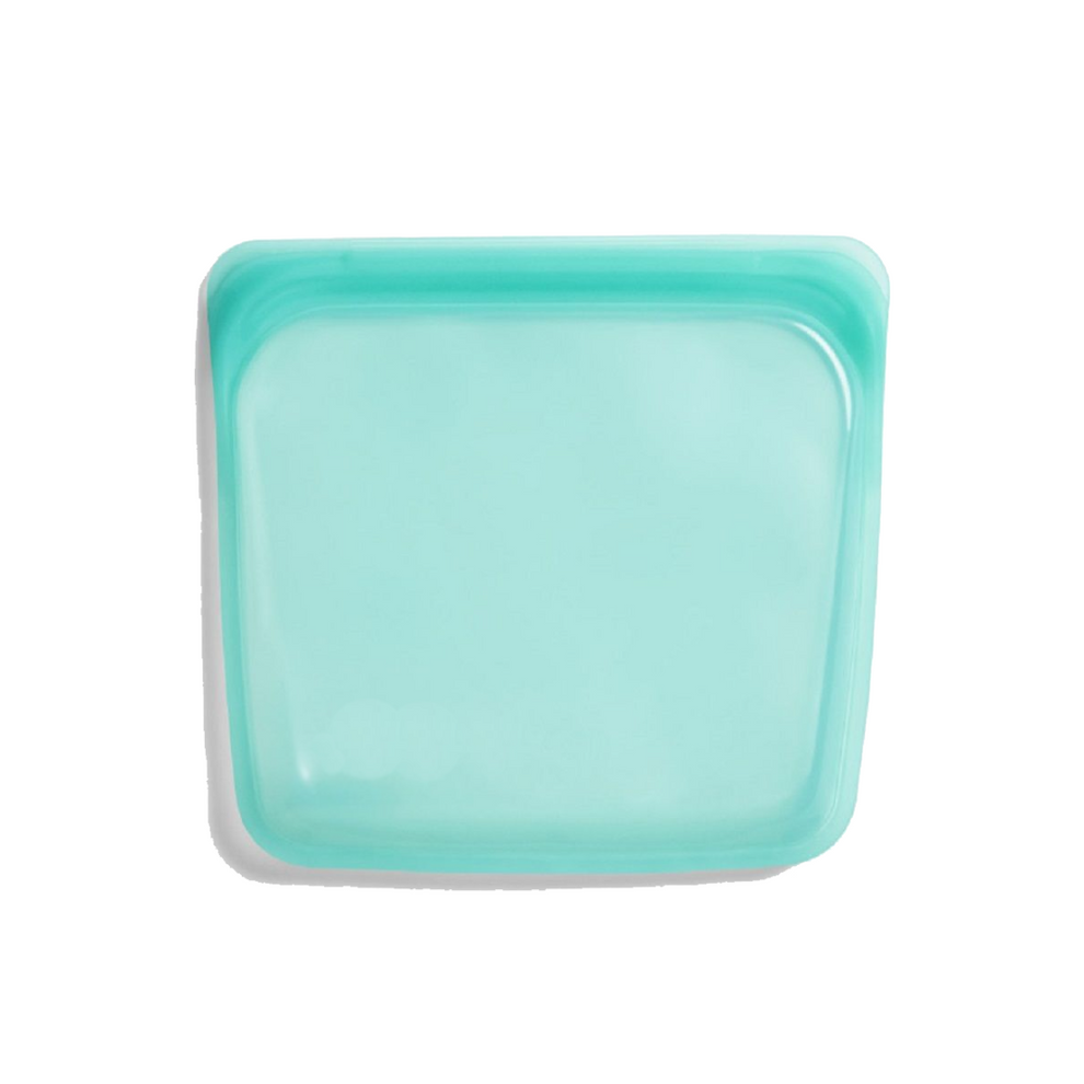 Reusable silicone food storage bags filled with fresh produce on a clean countertop